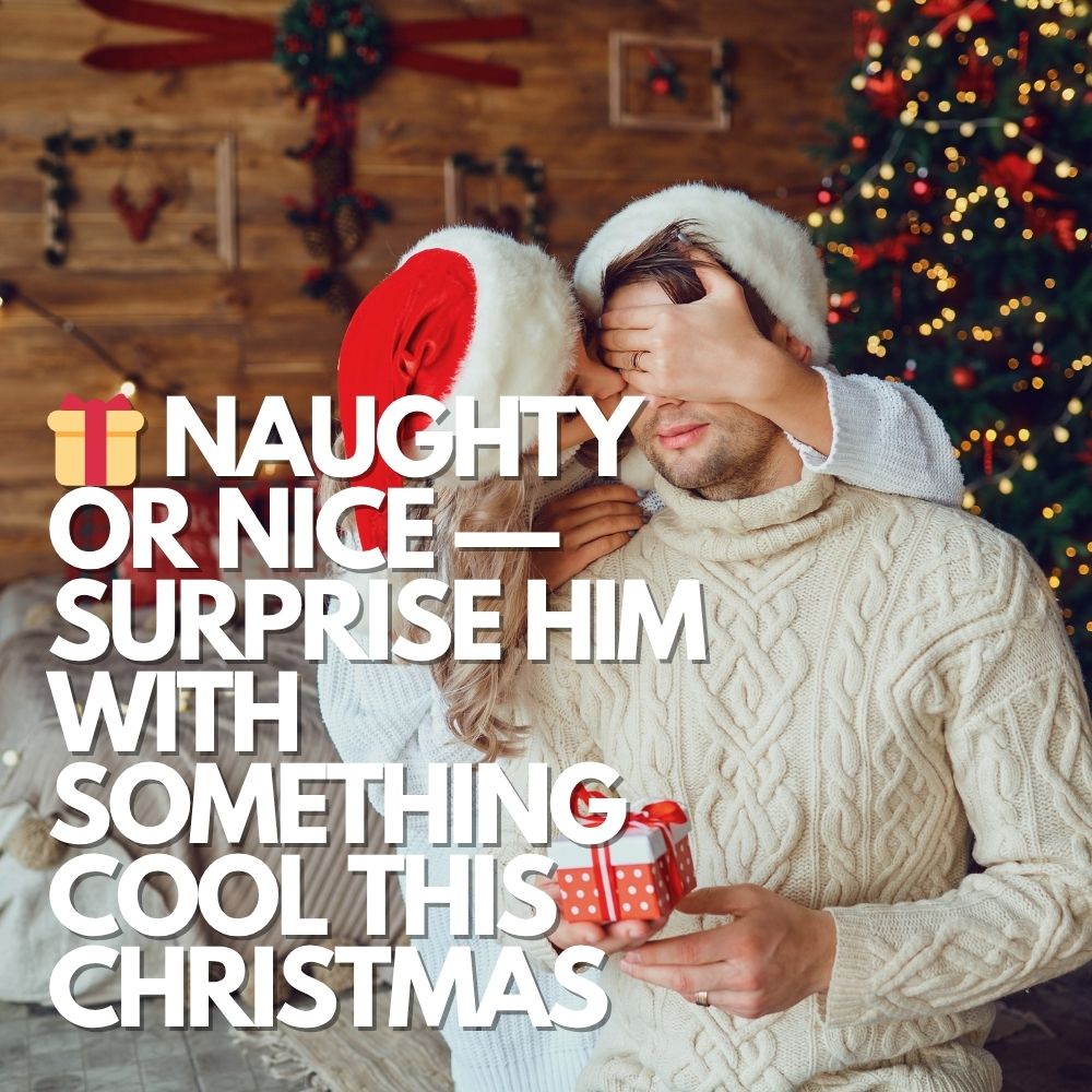 Young couple in cozy sweaters and Santa hats, celebrating Christmas morning with a cheeky surprise gift exchange.