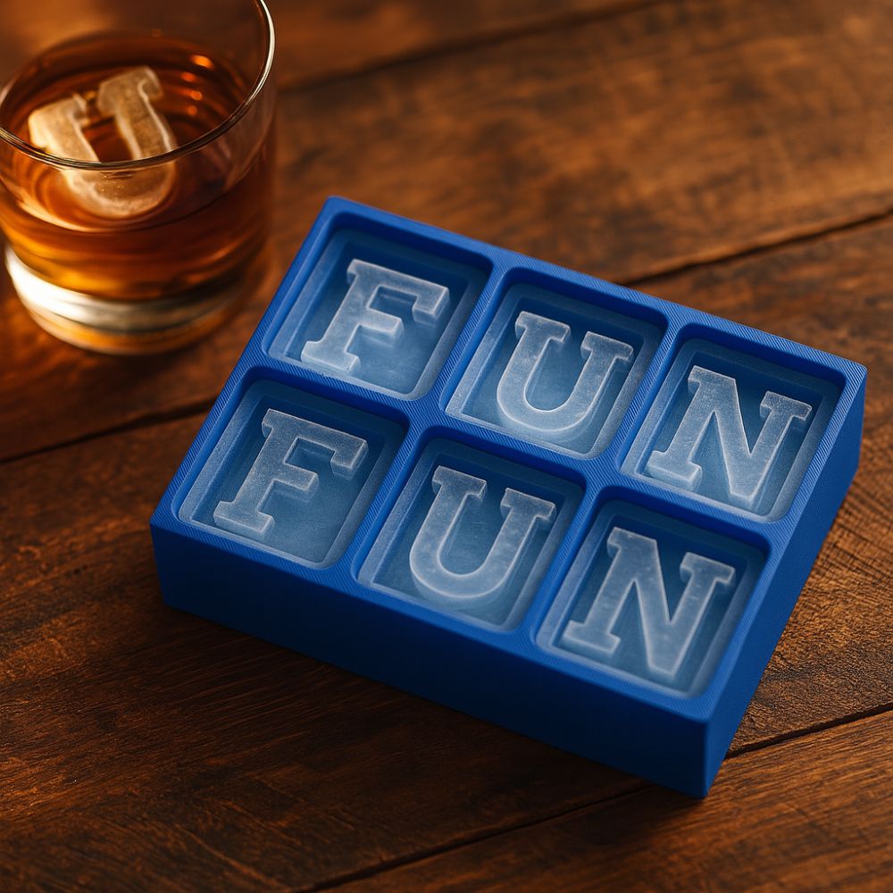 Blue silicone ice cube tray with FUN letter ice cubes, next to whiskey glass on rustic wooden table, showcasing playful custom drink moulds.