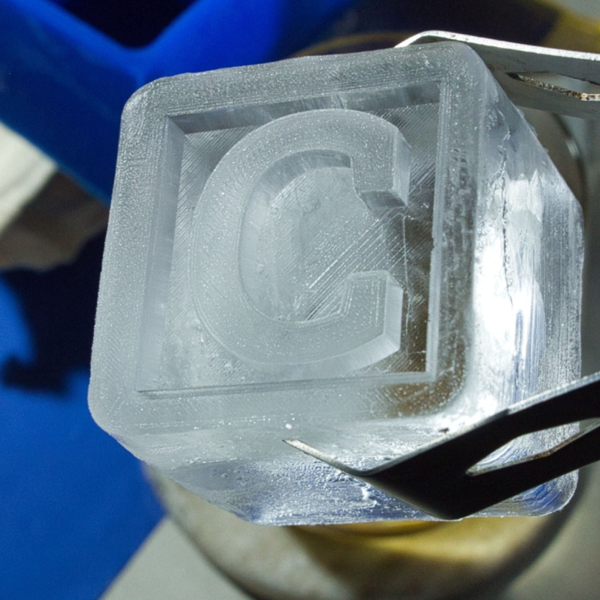 Macro shot of frosty “C” ice cube, showing crisp details for a unique gift for him