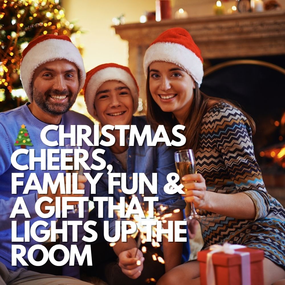 A smiling family gathered in front of a Christmas tree, enjoying sparklers and drinks—perfect setting for a gift to dad or husband.