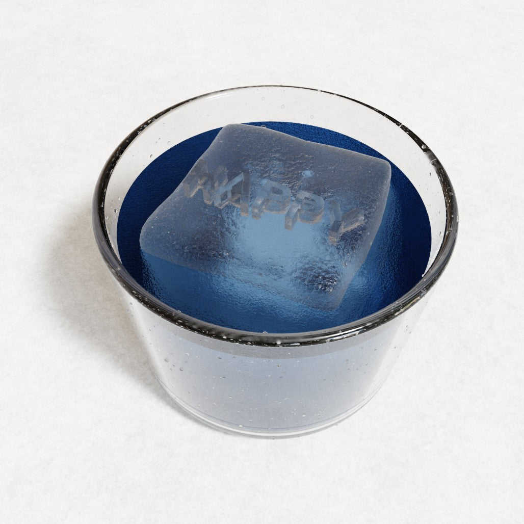 Blue drink with a large handmade ice cube embossed with HAPPY, made from a custom platinum-silicone mould by Chilled Out Creations, glowing under soft light.