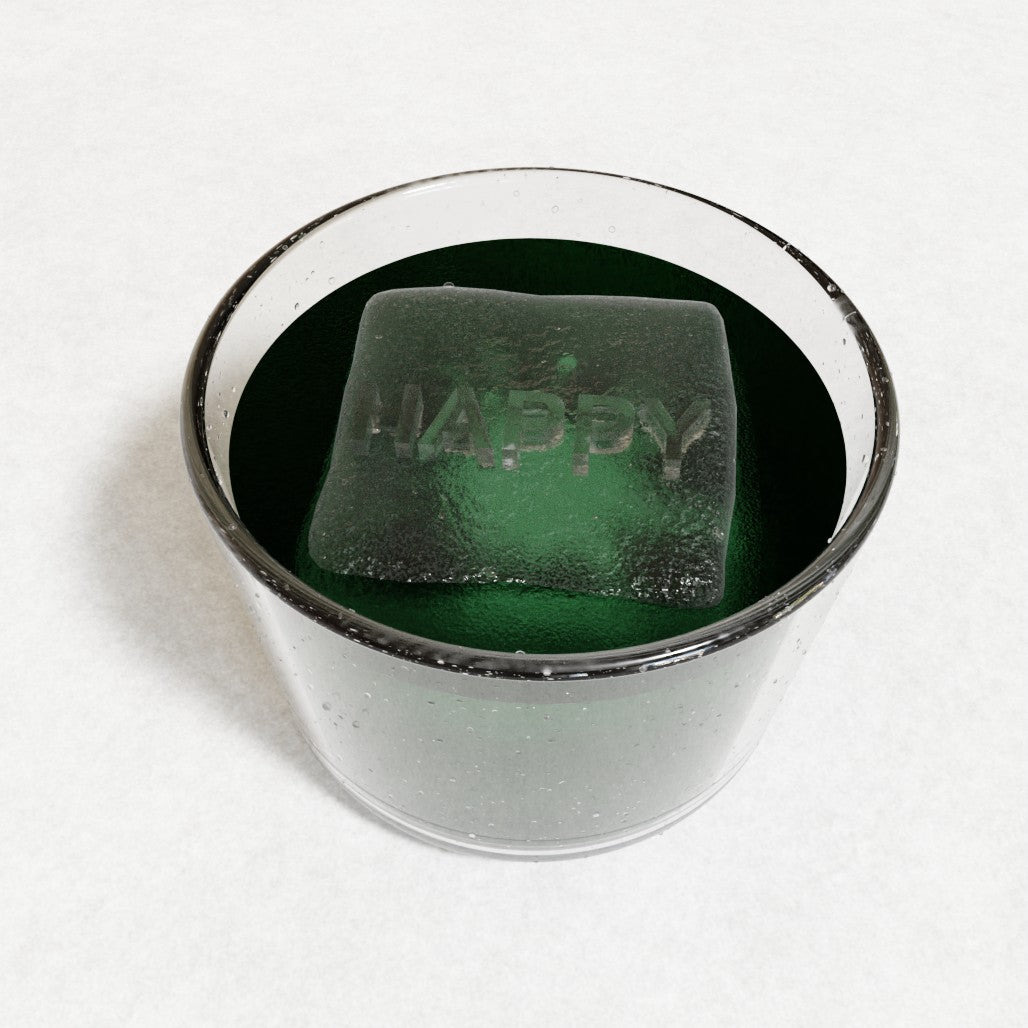 Close-up of a square ice cube engraved with HAPPY resting in a vivid green drink, representing a handmade custom mould from Chilled Out Creations Australia.