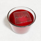 Red drink with a clear HAPPY ice cube crafted from a handmade platinum-silicone tray, capturing the warmth and joy of personalised Australian design.