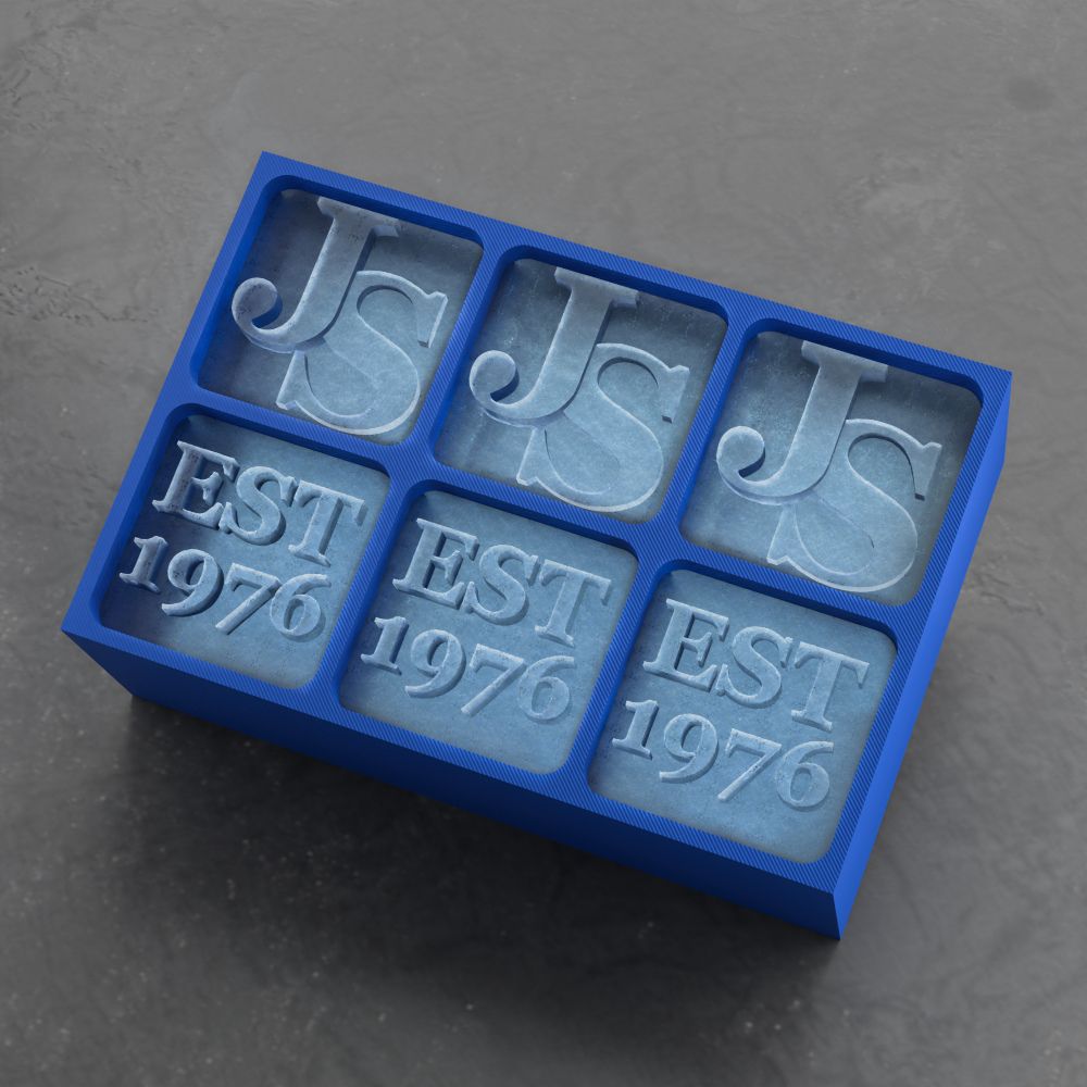 Blue silicone mold with 'JS' and 'EST 1976' text on a gray background