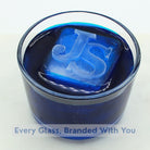 Blue ice cube with 'JS' branding in a glass of blue liquid.