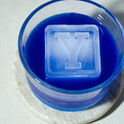 Personalised letter Y ice cube floating in vibrant blue drink, showcasing detail and clarity of custom tray design
