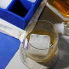 Close-up of a whiskey glass with a frosty custom ice cube engraved with ‘M & V’ initials – a heartfelt personalised detail for anniversaries, couples’ gifts, or elegant home bars.