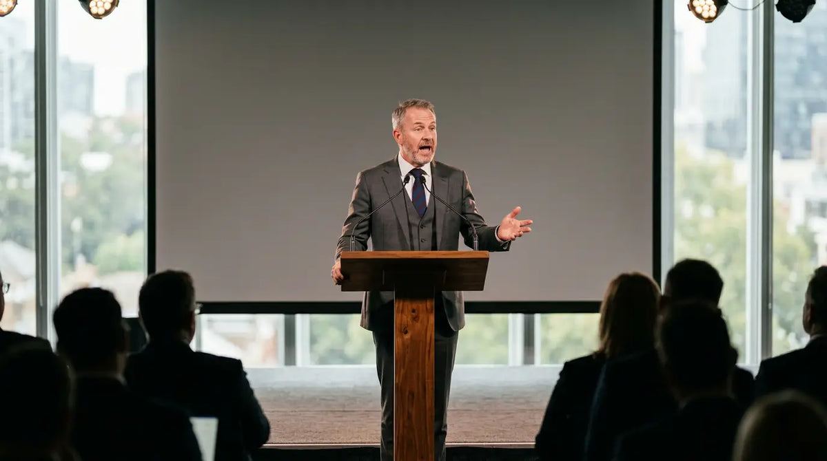 Conference speaker gifts Australia: keynote speaker at a lectern on stage at an Australian convention centre
