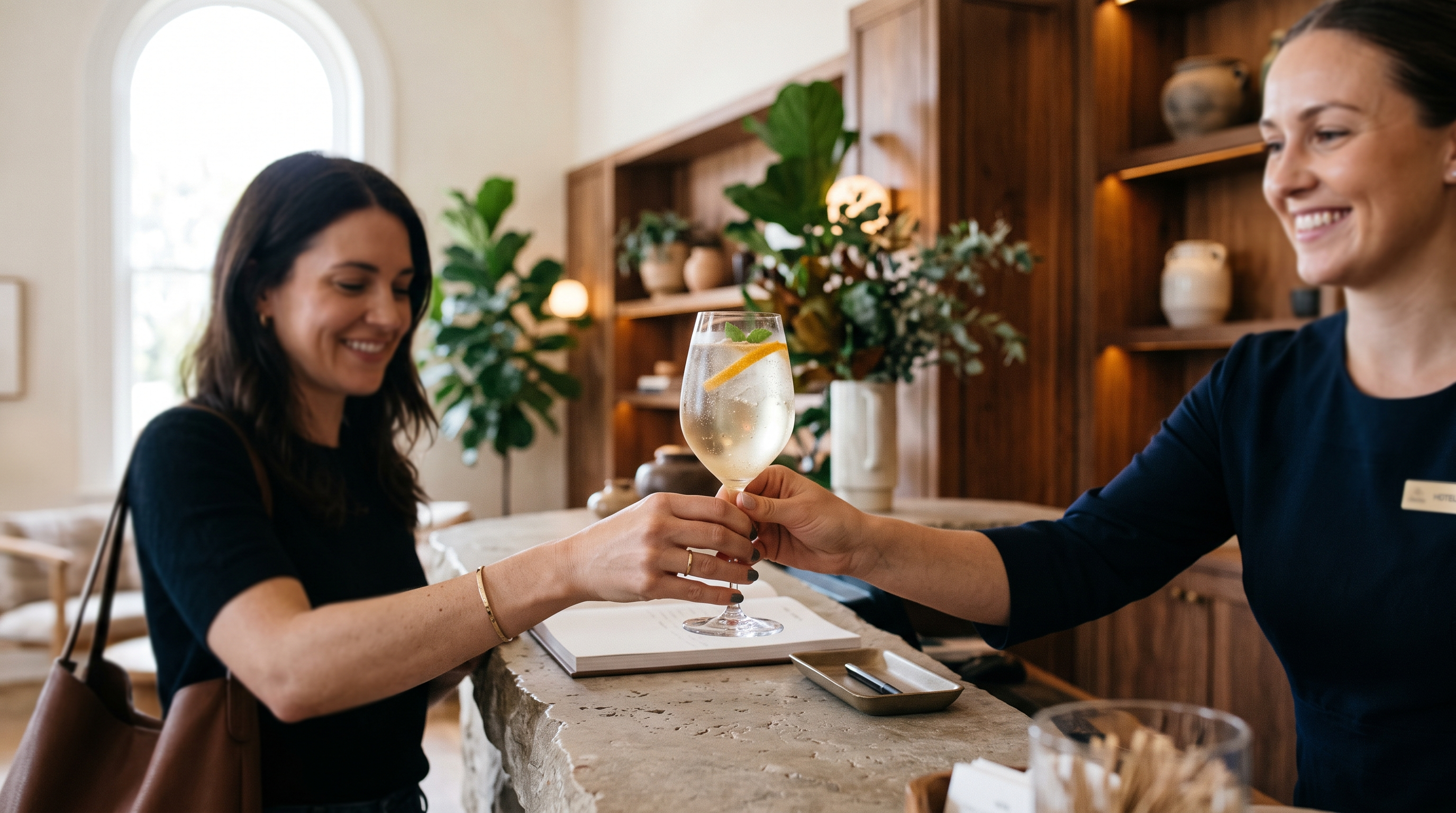 Hotel welcome drink handed to a guest at the check-in reception desk