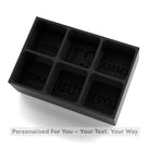 Black platinum-silicone ice tray with six cube cavities labelled EMMA, 21, CHEERS, LOVE, FUN, and DANCE — reusable custom word mould for drinks.