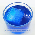 Elegant blue cocktail with a custom ice cube embossed with two initials joined by an ampersand, celebrating togetherness.