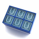 Blue silicone tray making six U-shaped monogram ice cubes, minimalist background – creative personalised present for birthdays, parties, or holiday celebrations.