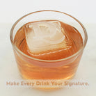 Whiskey-coloured drink with a custom 45 mm ice cube engraved with initials, overlay text “Make Every Drink Your Signature,” ideal for logos, bars, and business gifts.