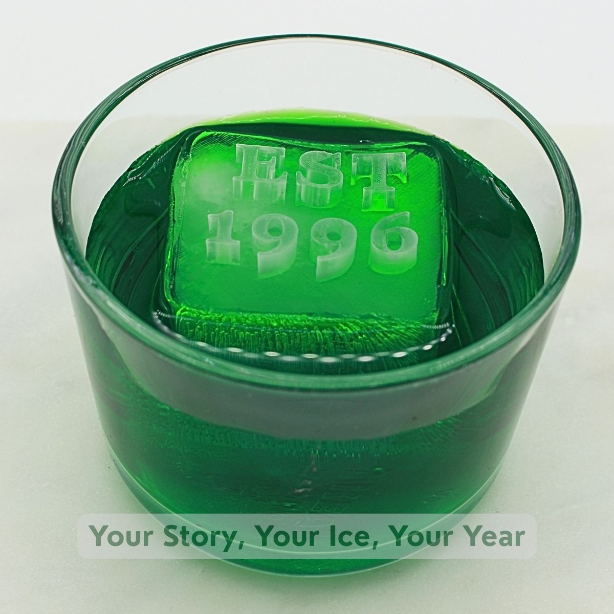 Green cocktail with floating custom ice cube featuring EST 1996 date text - personalized anniversary drink accessory