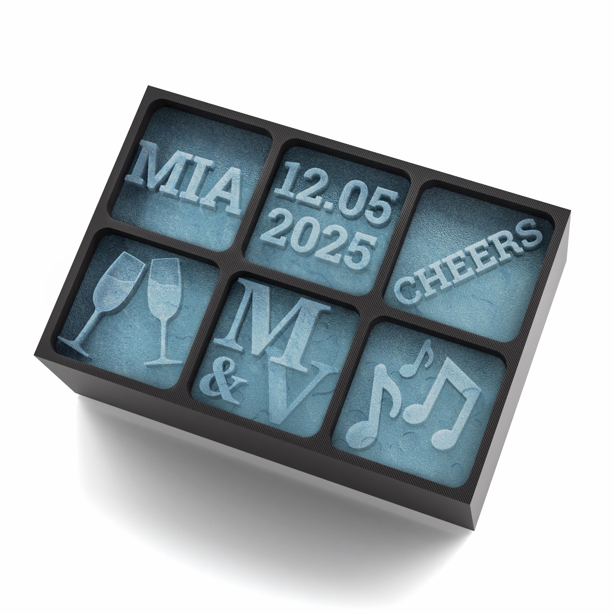 A black 6-cube silicone ice tray with custom designs including a name (MIA), a date (12.05.2025), word 'CHEERS', champagne glasses, initials (M & V), and music notes. Perfect for weddings, celebrations, or anniversaries.
