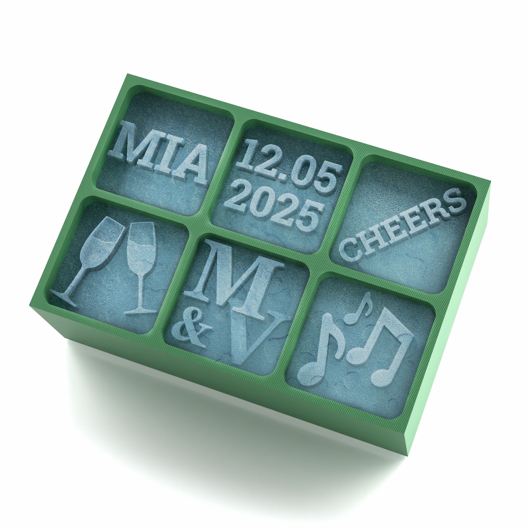 A green 6-cube silicone ice tray with custom designs including a name (MIA), a date (12.05.2025), word 'CHEERS', champagne glasses, initials (M & V), and music notes. Perfect for weddings, celebrations, or anniversaries.