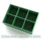 Forest green silicone ice tray with custom logo and initials cavities – reusable mould for unique branded ice cubes.