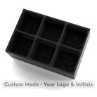 Sleek black silicone ice tray designed with logo and initials cavities – modern branded mould for corporate and bar use.