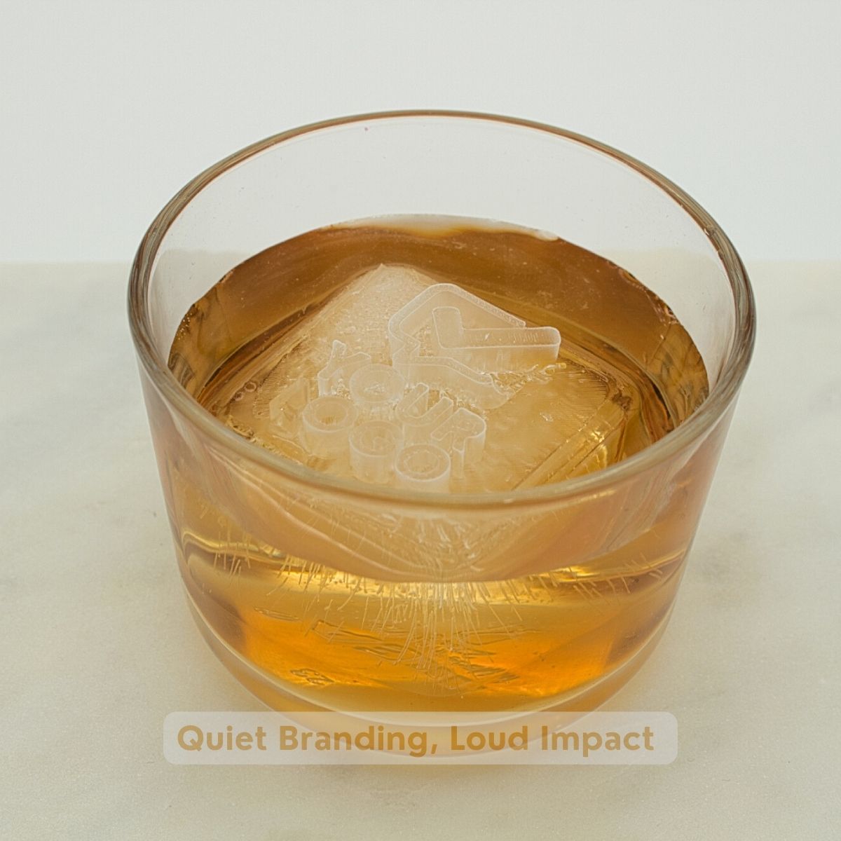Branded ice cube with company logo in a whisky glass, ideal for bars, events and corporate gifting; crisp imprint from a platinum-silicone tray.