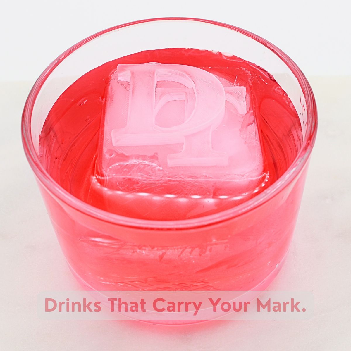 Red cocktail served with a DT monogram ice cube – unique personalised ice tray design.