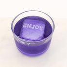 A cheerful purple drink featuring a clear ice cube engraved with “ENJOY,” made using a personalised message ice tray.
