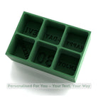 Green silicone mold with letter impressions on a white background