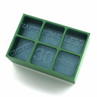 Green ice cube tray filled with blue ice, each engraved with birthday-themed text for a 30th celebration.