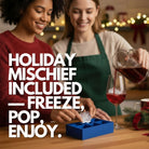 Two people preparing festive drinks with a blue elf ice tray on the counter, pouring cocktails and enjoying holiday celebration moments.