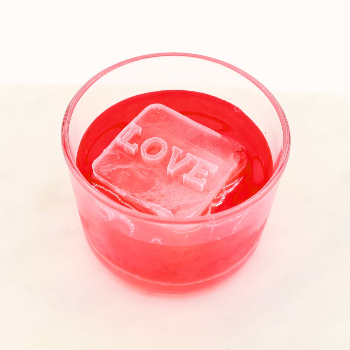 A red drink with a handmade “LOVE” ice cube, crafted using a custom platinum-silicone tray — perfect for romantic gifts.
