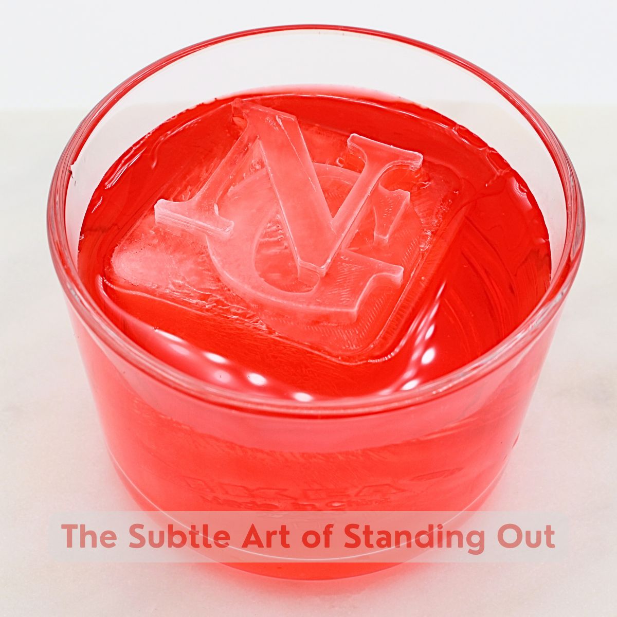 Custom NG monogram ice cube in a red cocktail – premium barware gift for stylish home bars.