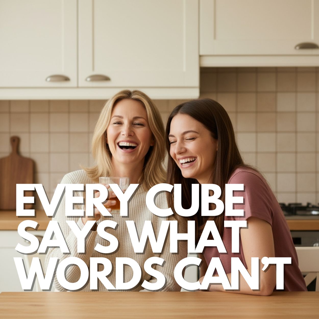 Smiling mother and daughter sharing a drink together in a bright kitchen, with text overlay reading “Every cube says what words can’t.” A warm, emotional lifestyle image for a handmade personalised gift for Mum.