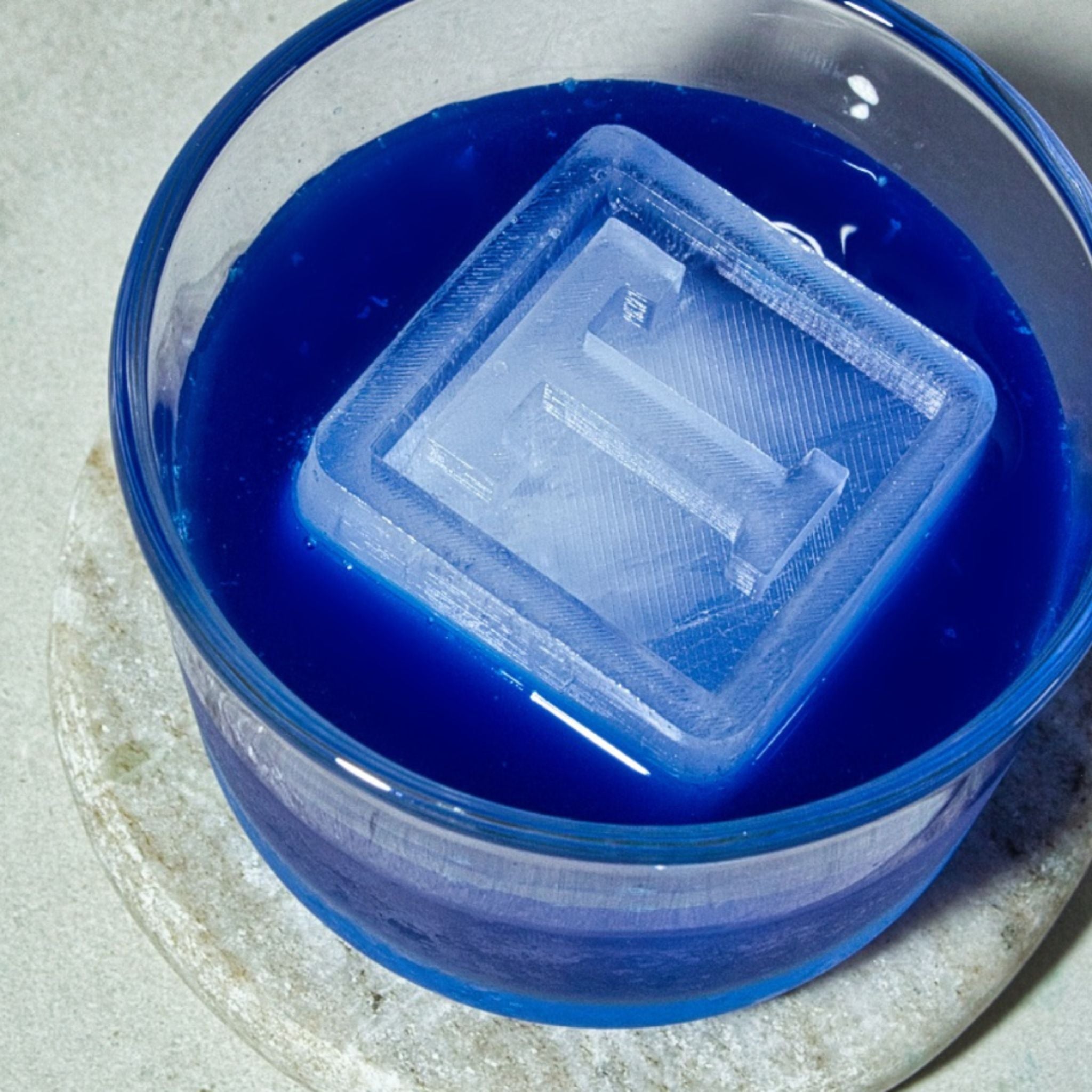 Handmade ‘T’ ice cube floating in a blue drink – a custom and playful present for parties, friends, or cocktail lovers.