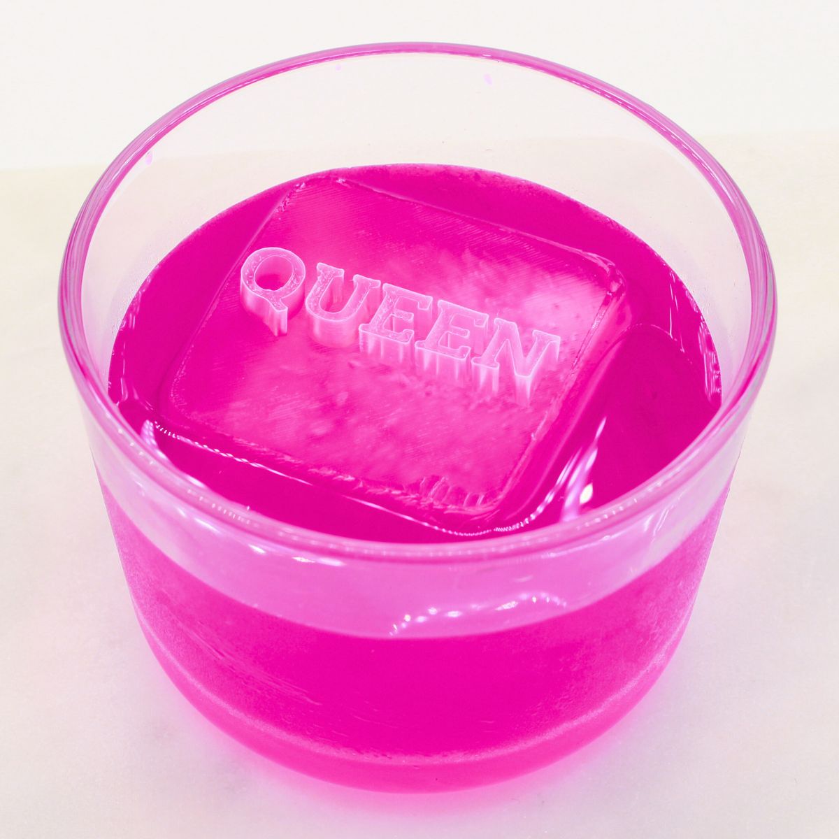 Pink ice cube with 'QUEEN' text on a white background