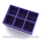 Purple silicone ice tray with six deep cube moulds labelled EMMA, 21, CHEERS, LOVE, FUN, and DANCE — reusable party drink accessory.