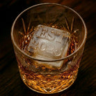Close-up of a whisky glass with an R&L Est 2025 monogrammed ice cube showing the EST 2025 engraving