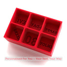 Red silicone mold with letter impressions on a white background