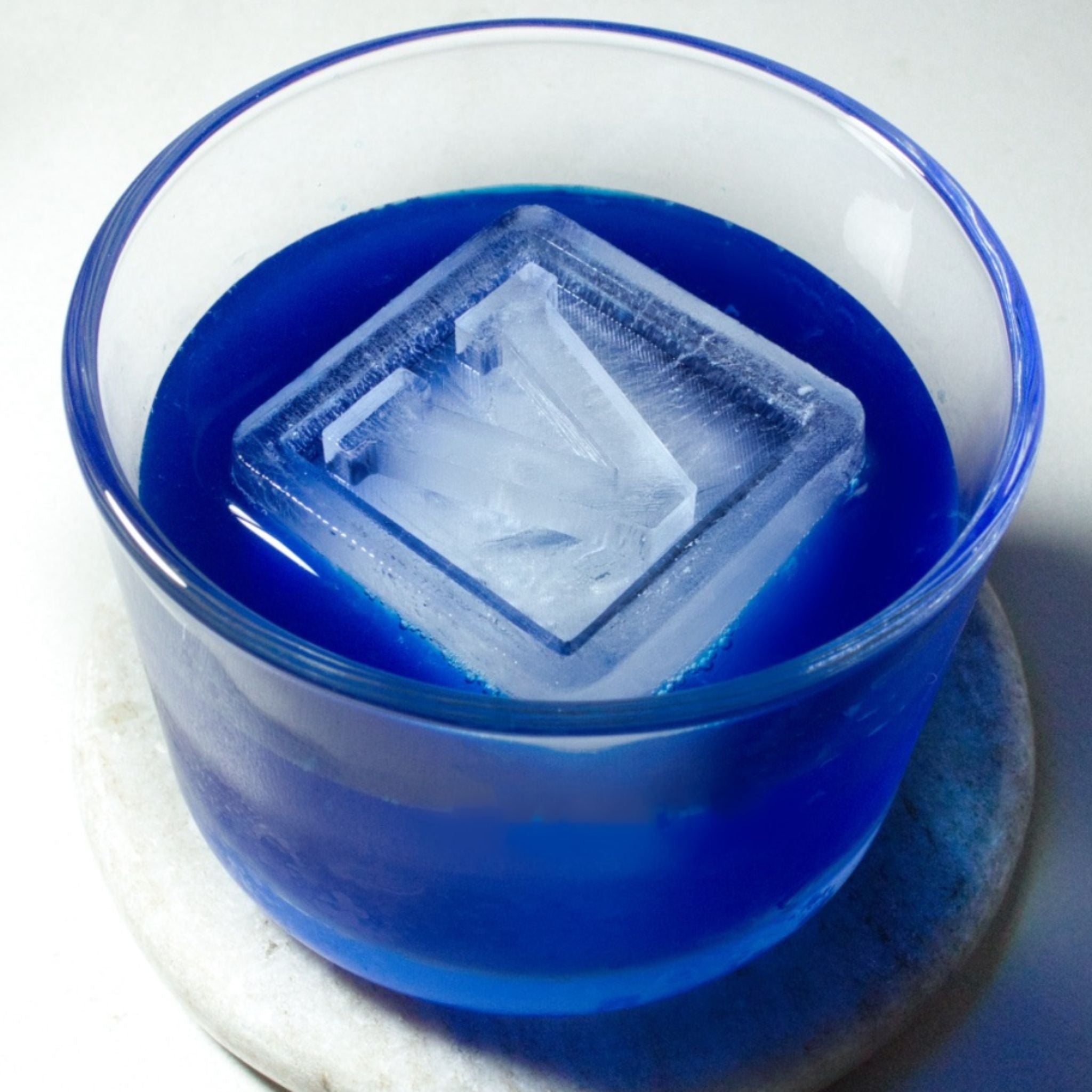 Personalised V ice cube in a vibrant blue cocktail, playful party gift or unique custom barware idea.