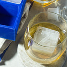 Clear Z ice cube in whiskey glass with tray nearby, perfect for showcasing personalised barware