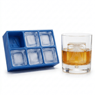 Blue Letter A ice tray next to a whiskey glass featuring a large A-embossed ice cube, bright natural light